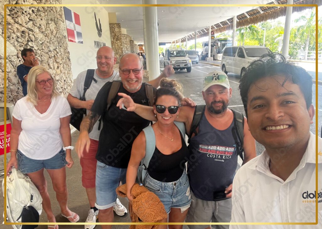 Group of smiling tourists posing with a GlobalDT driver at Punta Cana airport