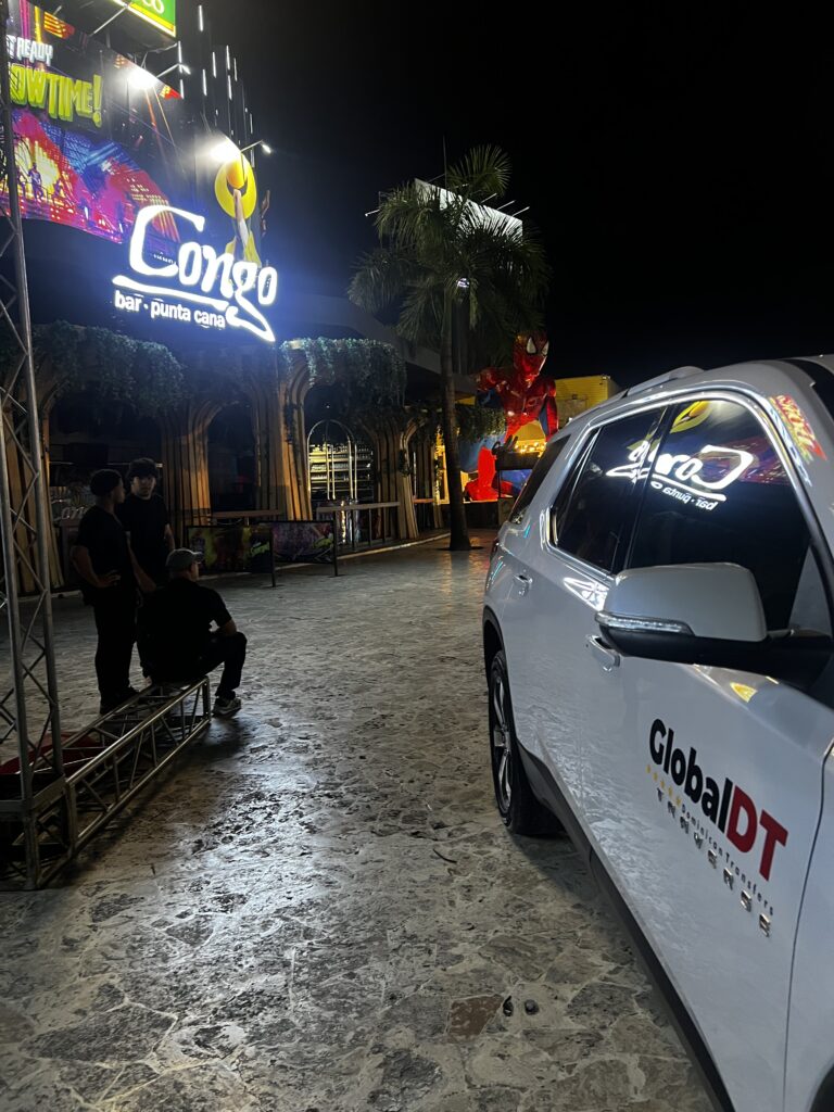 White Chevrolet Traverse with GlobalDT logo parked outside Congo Bar Punta Cana at night