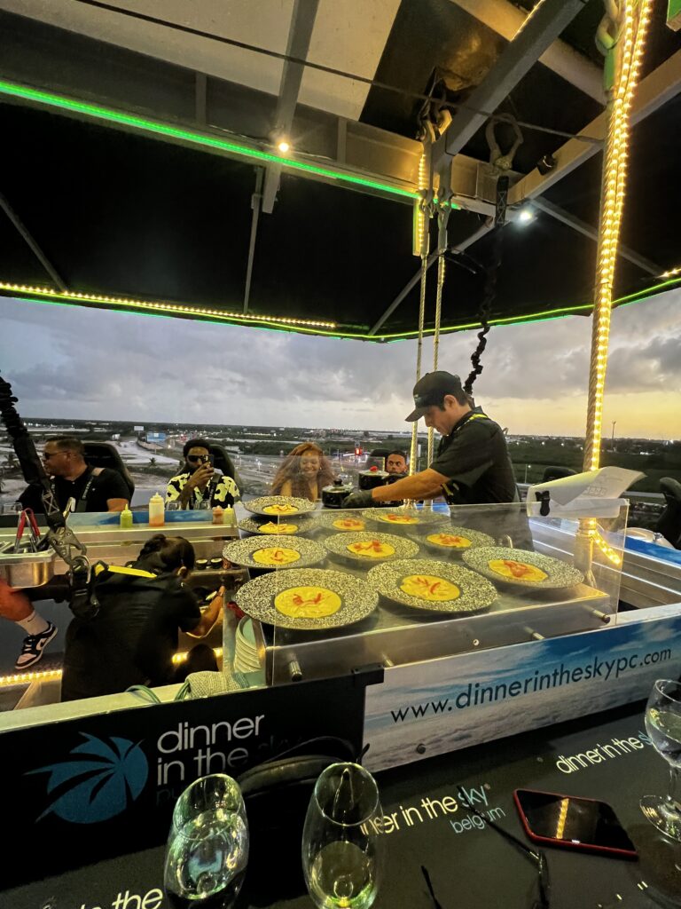 Chef sirve platos en la plataforma Dinner in the Sky al atardecer en Punta Cana