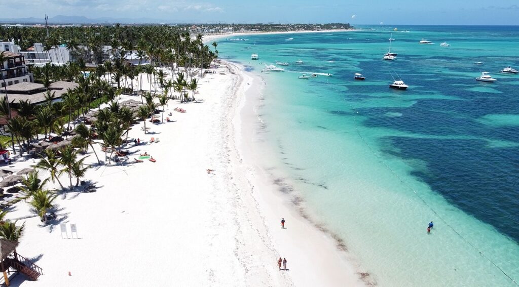 Vista aerea de Playa Bavaro con arena blanca, mar turquesa y botes anclados en Punta Cana