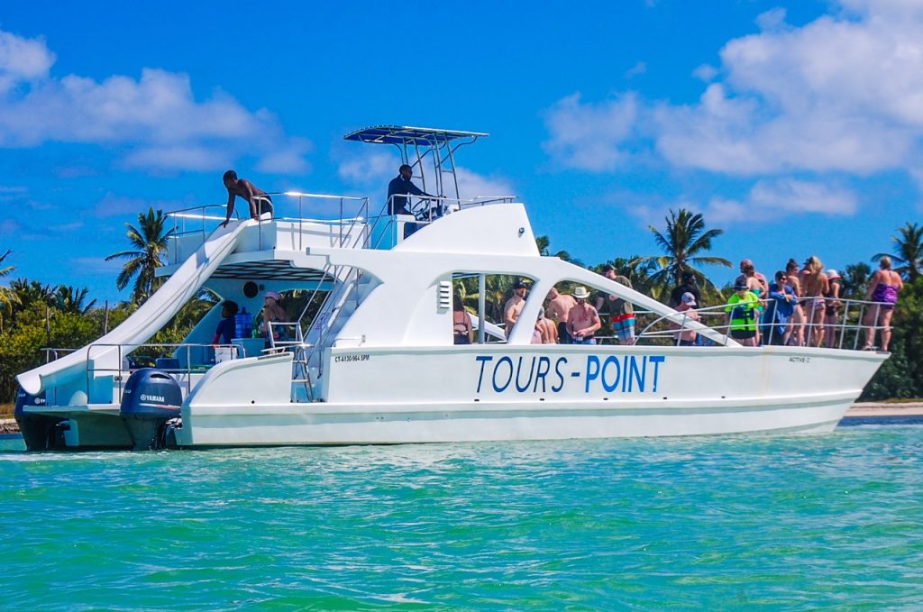 Paseo en catamarán con pasajeros sobre aguas turquesas bajo un cielo azul