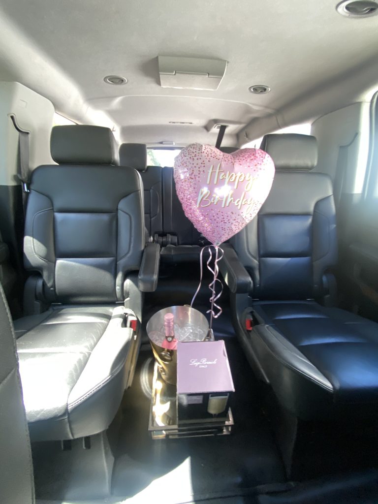 Chevrolet Suburban interior with Happy Birthday balloon, champagne on ice and gift box