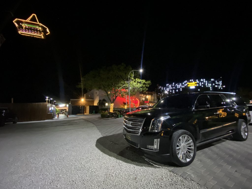 Cadillac Escalade negro de noche junto a un local de entretenimiento en Punta Cana