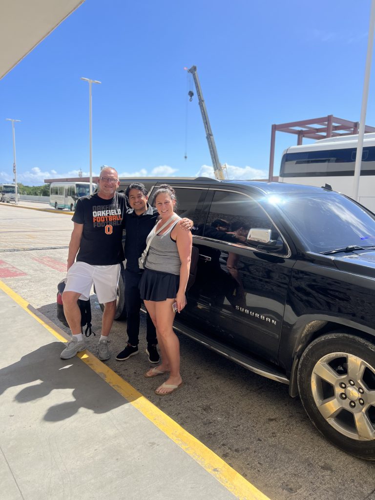 Travelers beside a black Chevrolet Suburban at Punta Cana airport