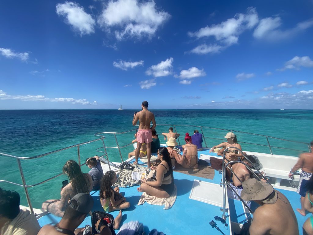 Viajeros en un catamarán sobre agua turquesa cerca de Isla Saona