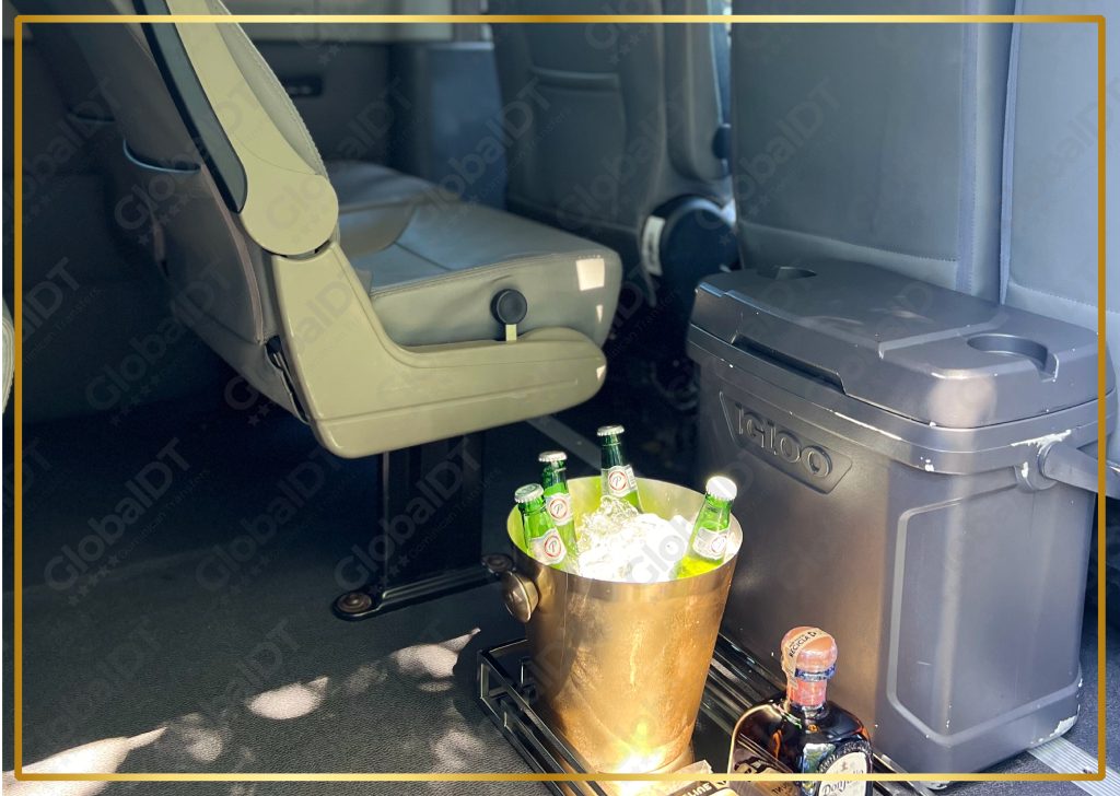 Igloo cooler and gold ice bucket with chilled drinks inside a passenger van